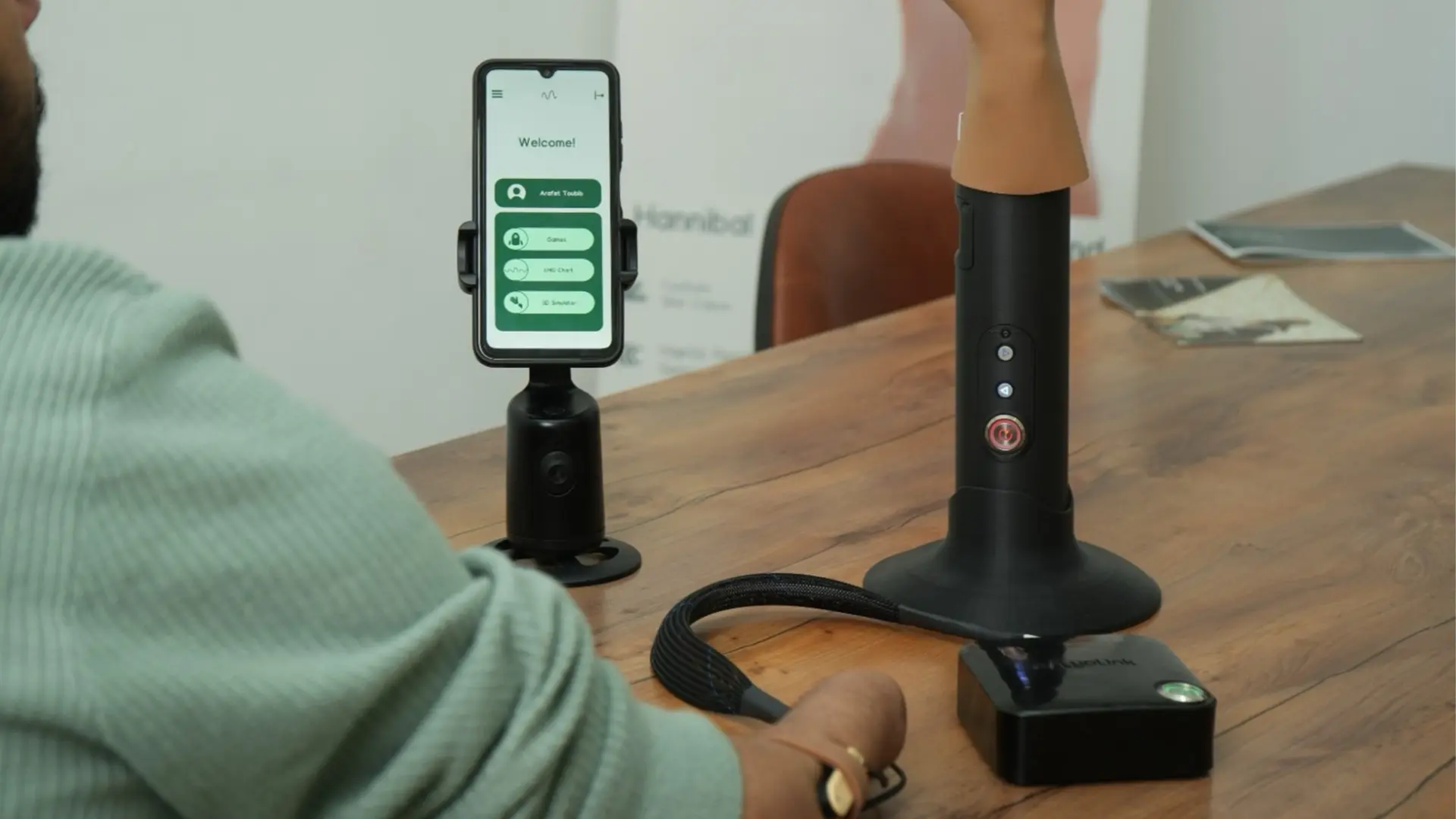 MyoSense muscle training session with a prosthetic arm and the training app on a phone
