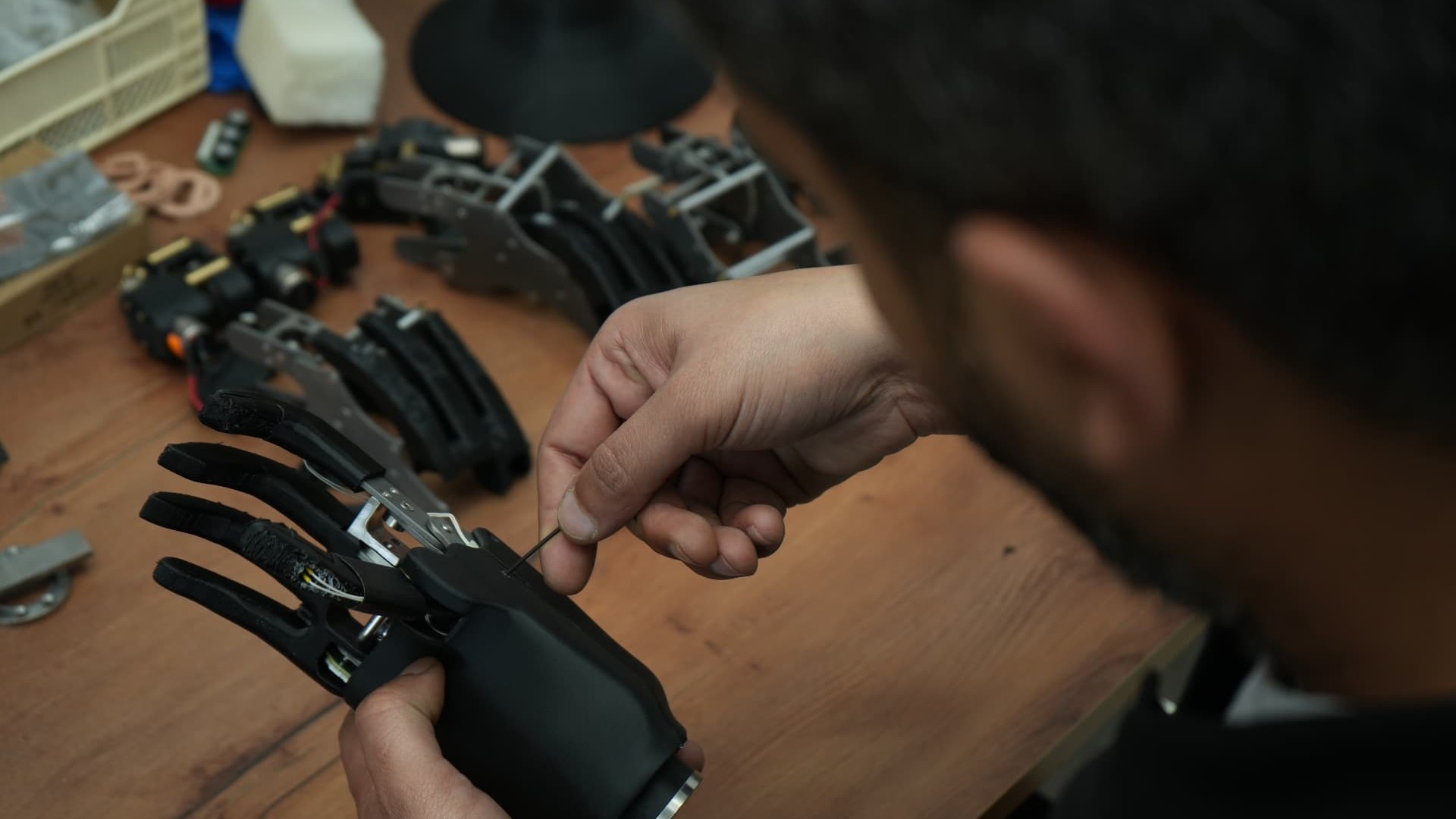 مهندس يقوم بتجميع يد بيونية من Cure Bionics على طاولة العمل